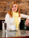 First cappuccino - Beautiful young caucasian girl drinking coffee in a bar in early morning