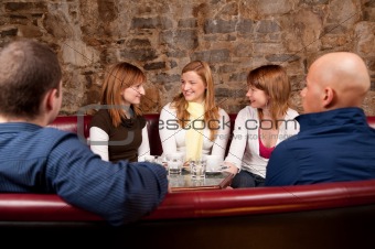 Group of five people having fun in cafe