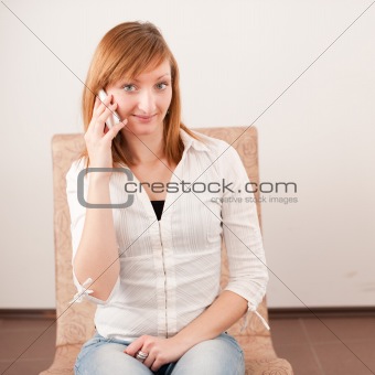 Beautiful girl speaks on mobile phone in cosy cafe. 