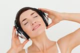 Close up of a delighted brunette listening to music