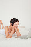Portrait of a young woman listening to music with her laptop