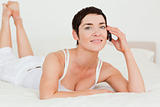 Woman calling while lying on her bed