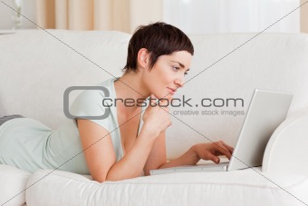 Focused short-haired woman using a laptop