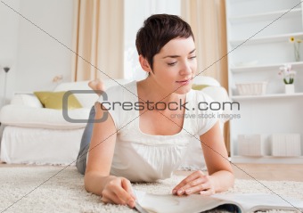 Cute brunette reading a magazine