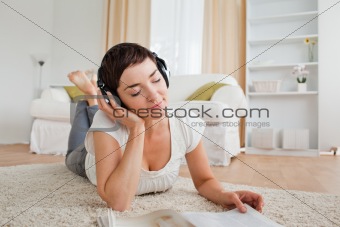 Cute woman with a magazine enjoying some music