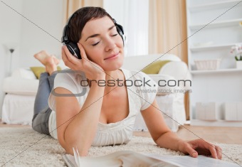Delighted woman with a magazine enjoying some music