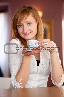 First capuccino - Beautiful young caucasian girl drinking coffee in a bar in early morning