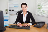 Serious secretary typing on her keybord