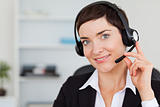 Close up of a smiling secretary calling with a headset