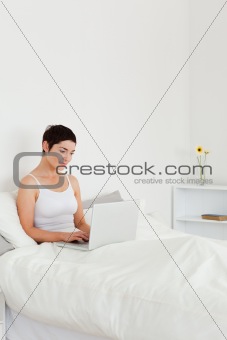 Good looking brunette using a laptop