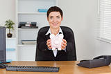 Smiling office worker holding a piggybank