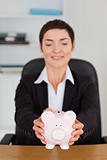 Portrait of an office worker holding a piggybank