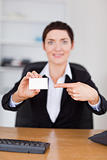 Portrait of a secrertary pointing at a blank business card