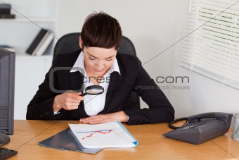 Woman looking at a chart with a magnifying glass