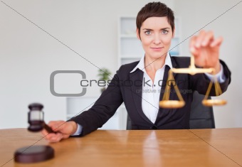 Serious woman with a gavel and the justice scale