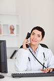 Portrait of a  smiling female doctor making a phone call