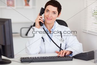 Smiling female doctor making a phone call