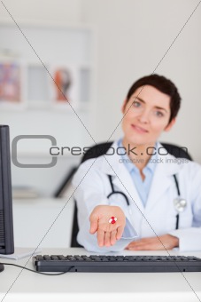Portrait of a female doctor showing pills