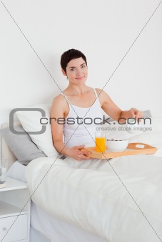 Portrait of a cute woman pouring milk into her cereal