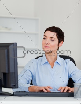Portrait of a serious businesswoman typing wiht her computer