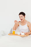 Portrait of a cute woman eating cereal