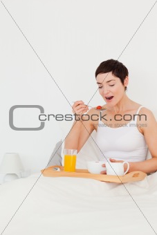 Portrait of a cute woman eating cereal