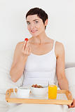 Lovely woman eating a strawberry