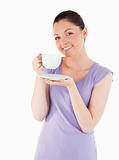 Charming female enjoying a cup of coffee while standing