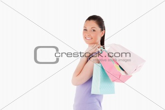 Charming woman holding shopping bags while standing