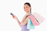 Attractive woman with a credit card holding shopping bags while 
