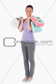 Lovely woman holding shopping bags while standing