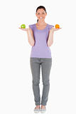 Beautiful woman holding fruits while standing
