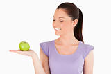Good looking woman holding an apple while standing