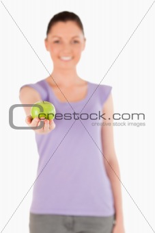Lovely woman holding an apple while standing
