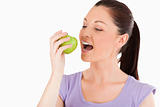 Lovely woman eating an apple while standing