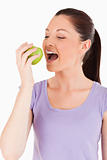Beautiful woman eating an apple while standing