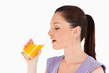 Beautiful woman drinking a glass of orange juice while standing