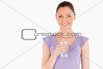 Beautiful woman holding a glass of water while standing