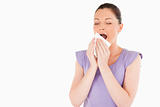 Beautiful woman sneezing while standing