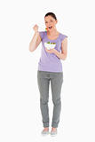 Gorgeous woman eating a bowl of salad while standing