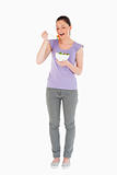 Pretty woman eating a bowl of salad while standing
