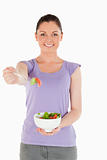 Attractive woman holding a bowl of salad while standing