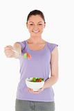 Gorgeous woman holding a bowl of salad while standing