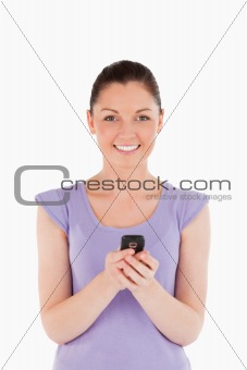 Attractive woman writing a text on her phone while standing