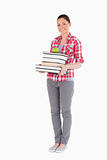 Good looking female holding and a apple and books while posing