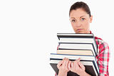 Sad female posing with books while standing