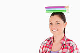Gorgeous female holding books on her head while standing