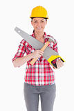 Pretty woman holding a saw while standing