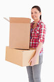 Attractive woman holding cardboard boxes while standing