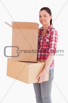 Attractive woman holding cardboard boxes while standing